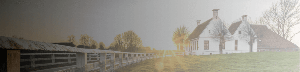 Sunlit rural landscape with farmhouse and fields
